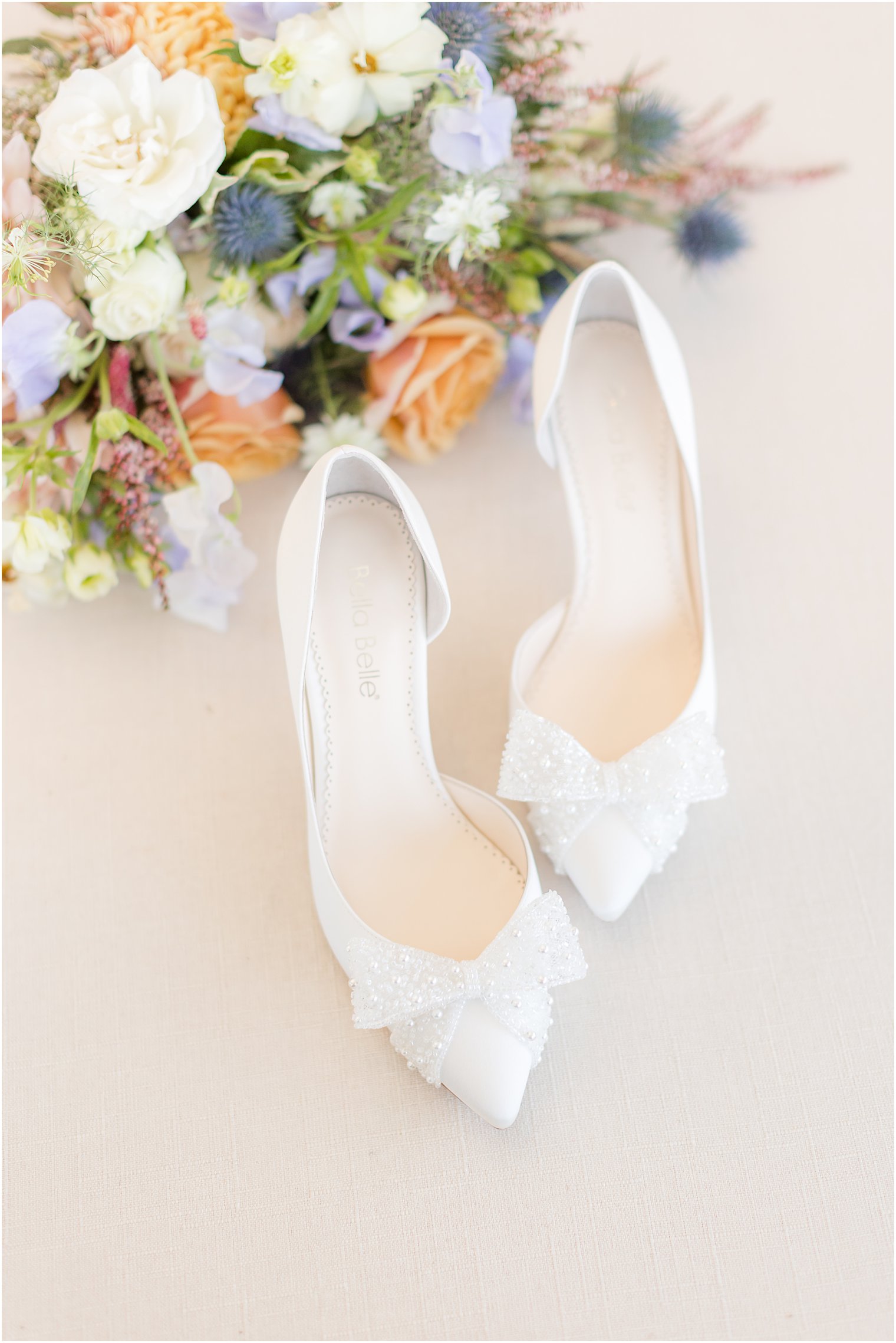 bride's white shoes with bows for spring wedding day