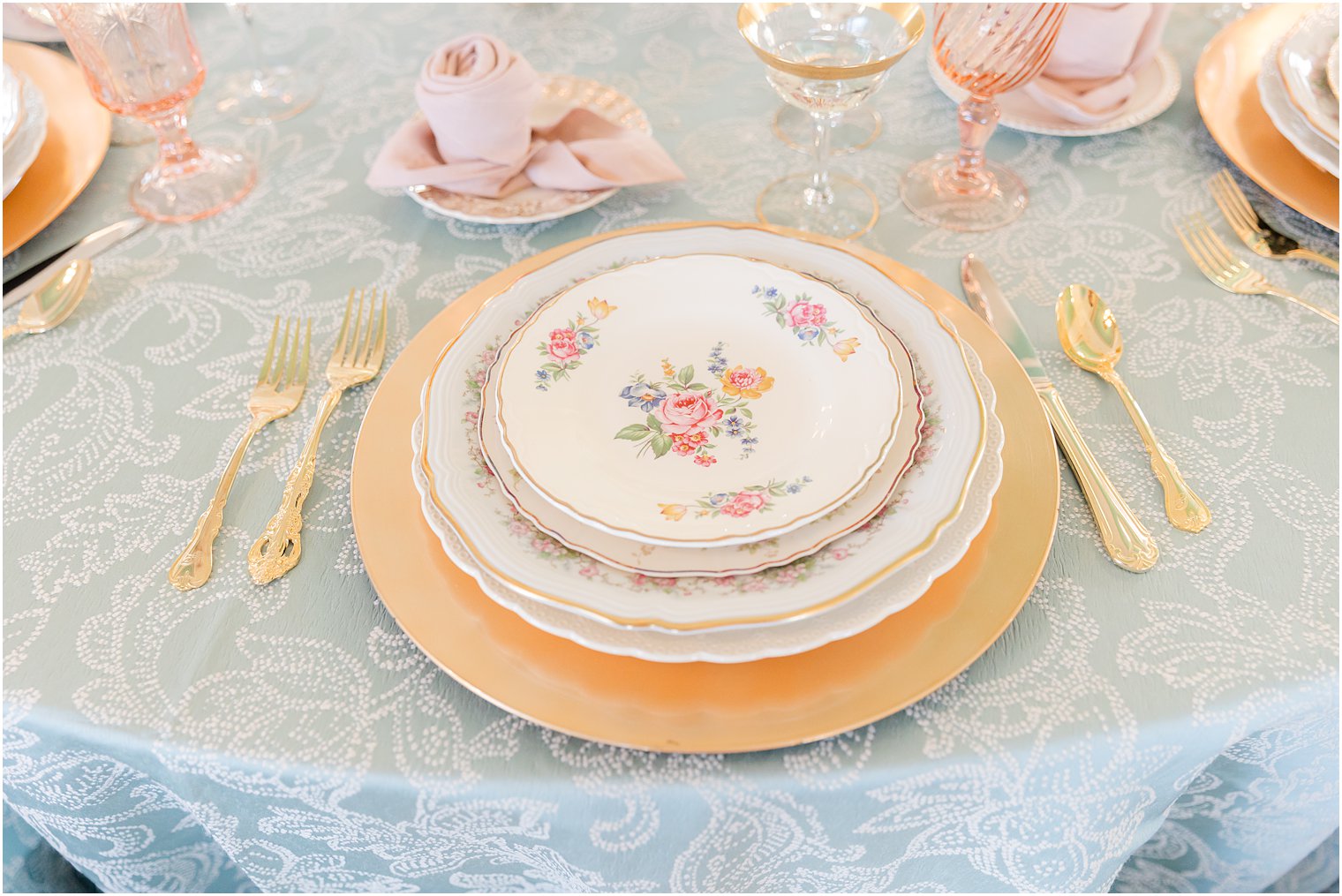 place setting with vintage china on gold chargers