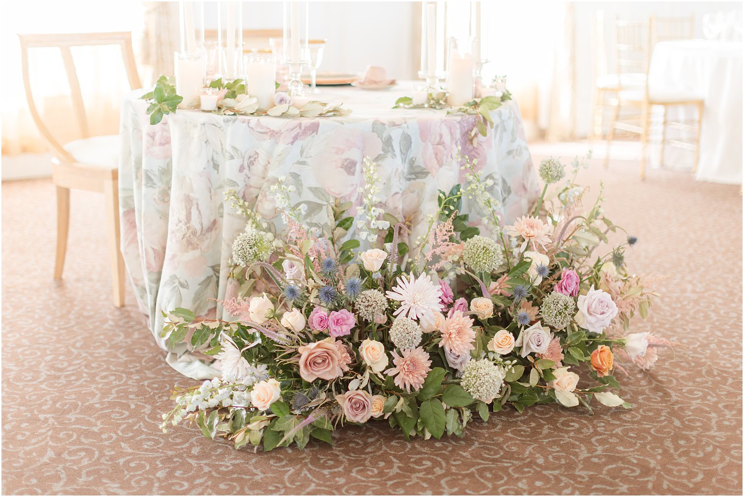 sweetheart table with blue and white table cloth with floral display in front