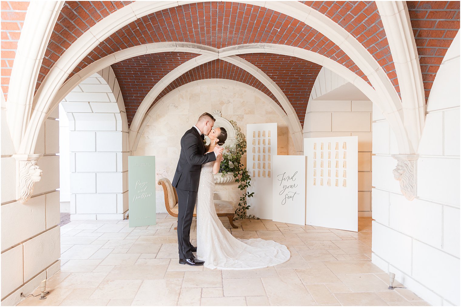 New Jersey couple kisses by seating cards at Mallard Island Yacht Club