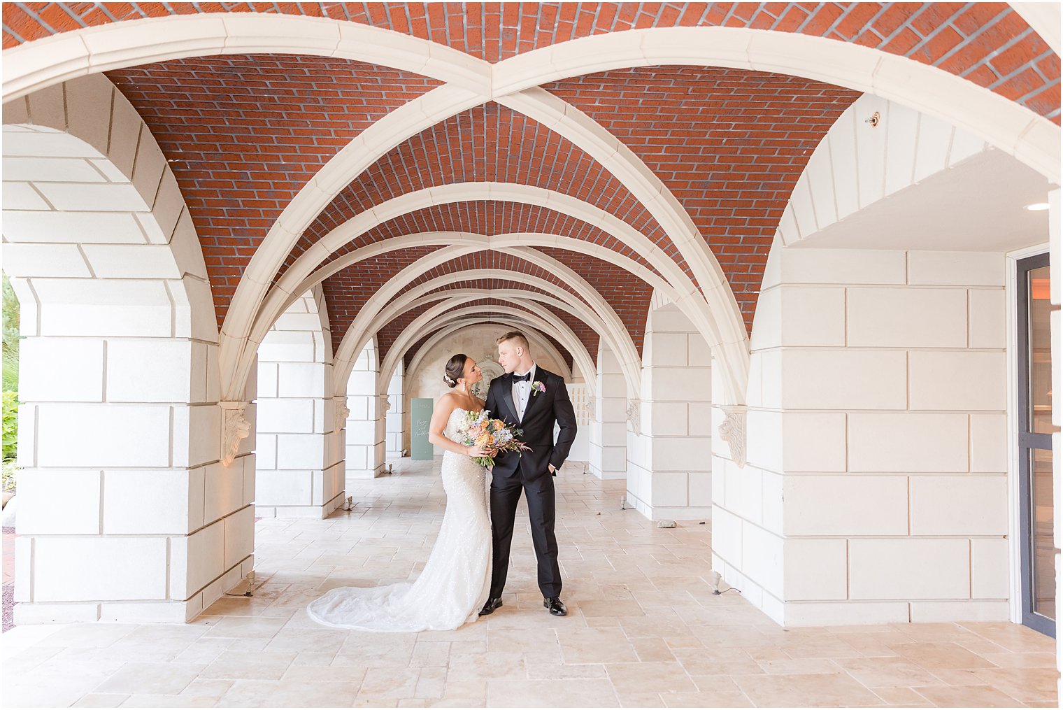 bride and groom stand together in hallway at Mallard Island Yacht Club