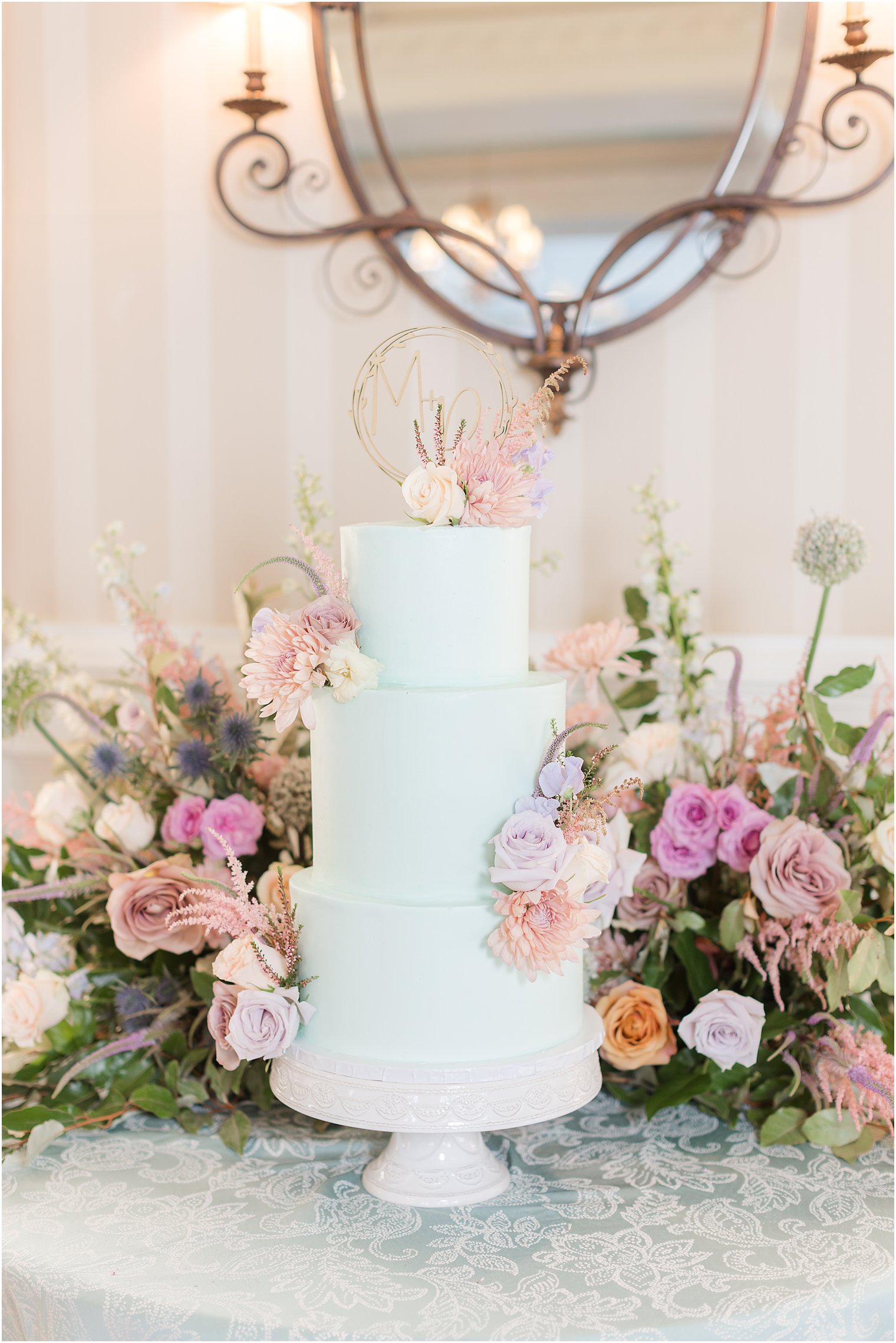 tiered wedding cake sitting on blue table cloth at Mallard Island Yacht Club