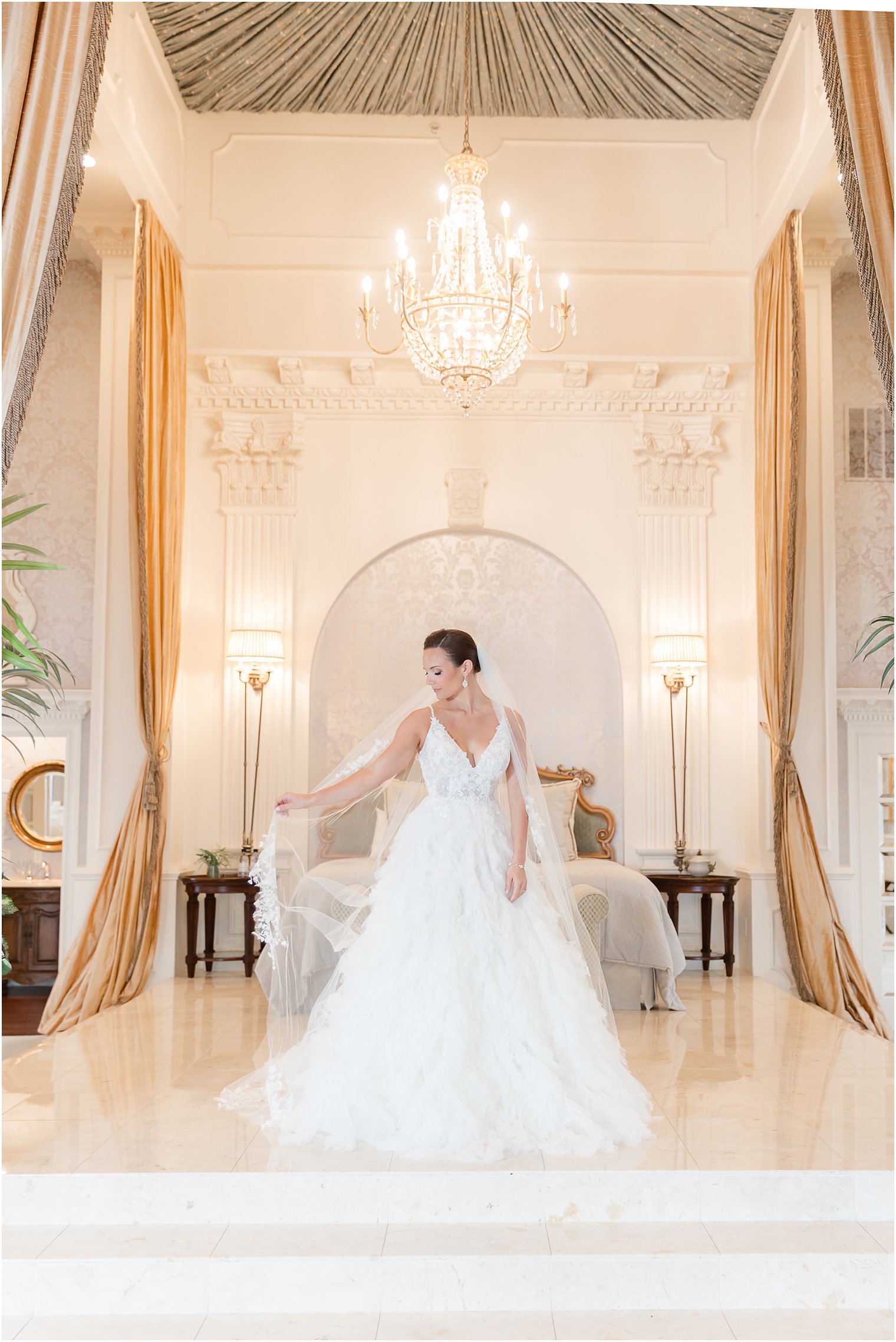 bride holds out veil around her in suite at Mallard Island Yacht Club