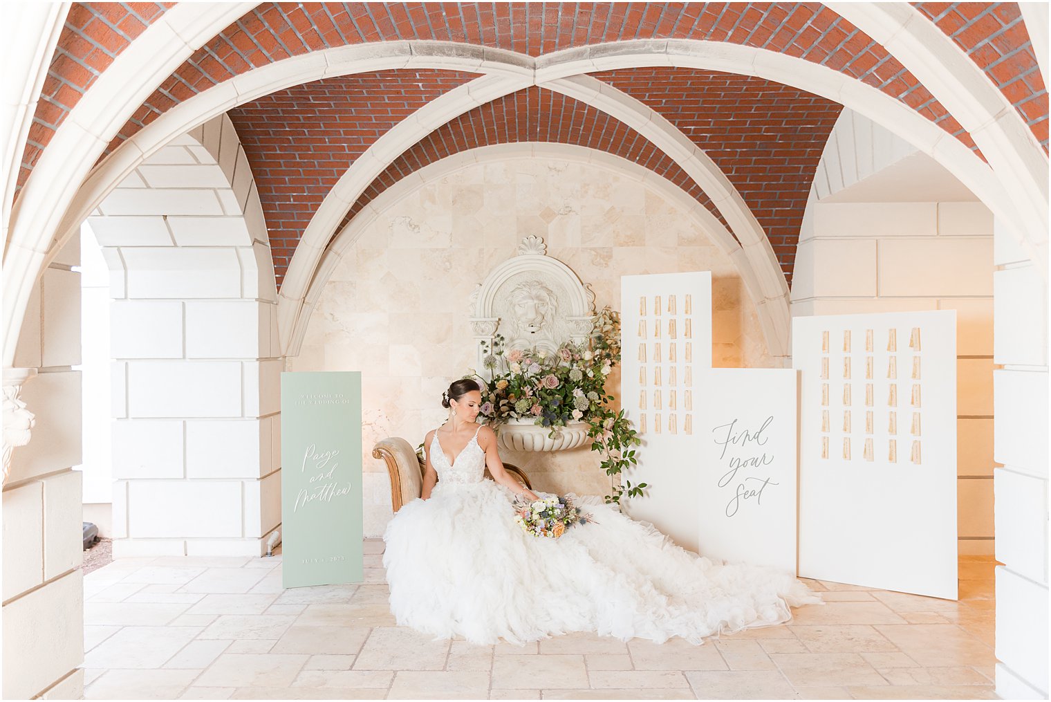 bride sits in front of seating chart at Mallard Island Yacht Club