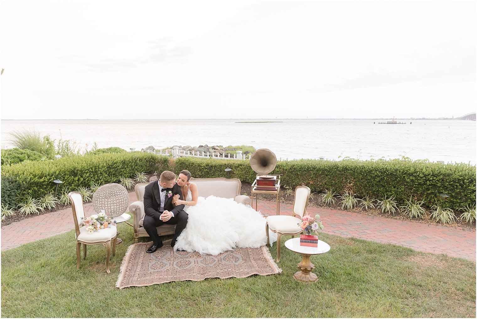 bride and groom kiss sitting on couch outside Mallard Island Yacht Club