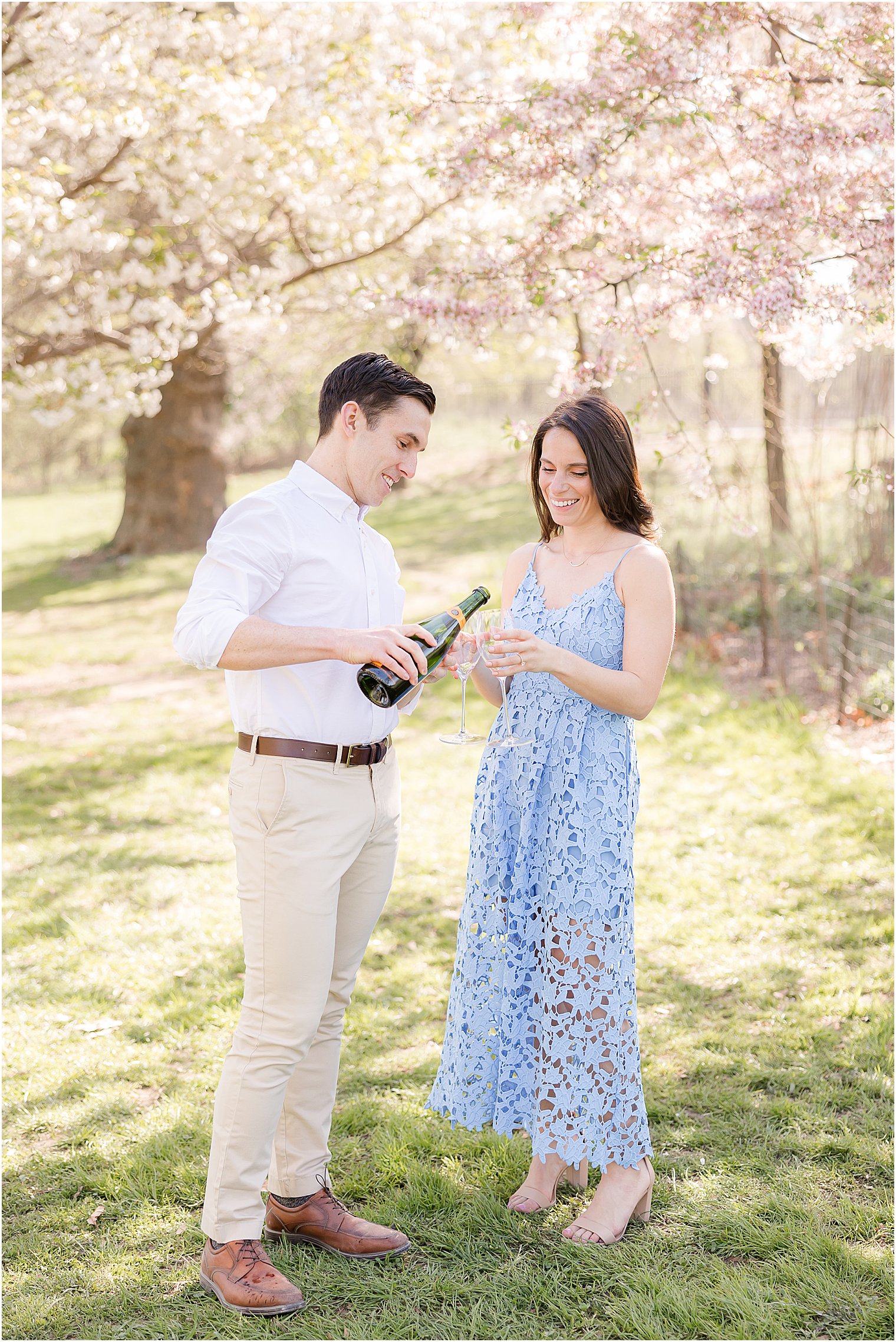 man pours woman champagne during New York City engagement session