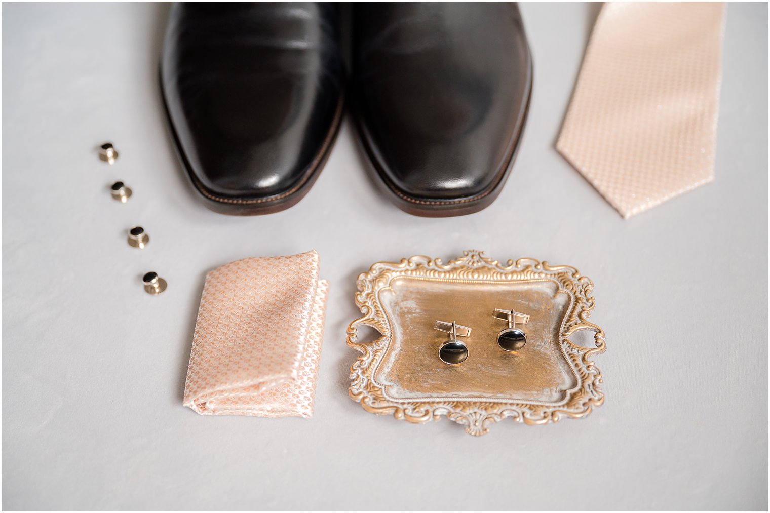 groom's black shoes, cufflinks and peach tie for spring wedding