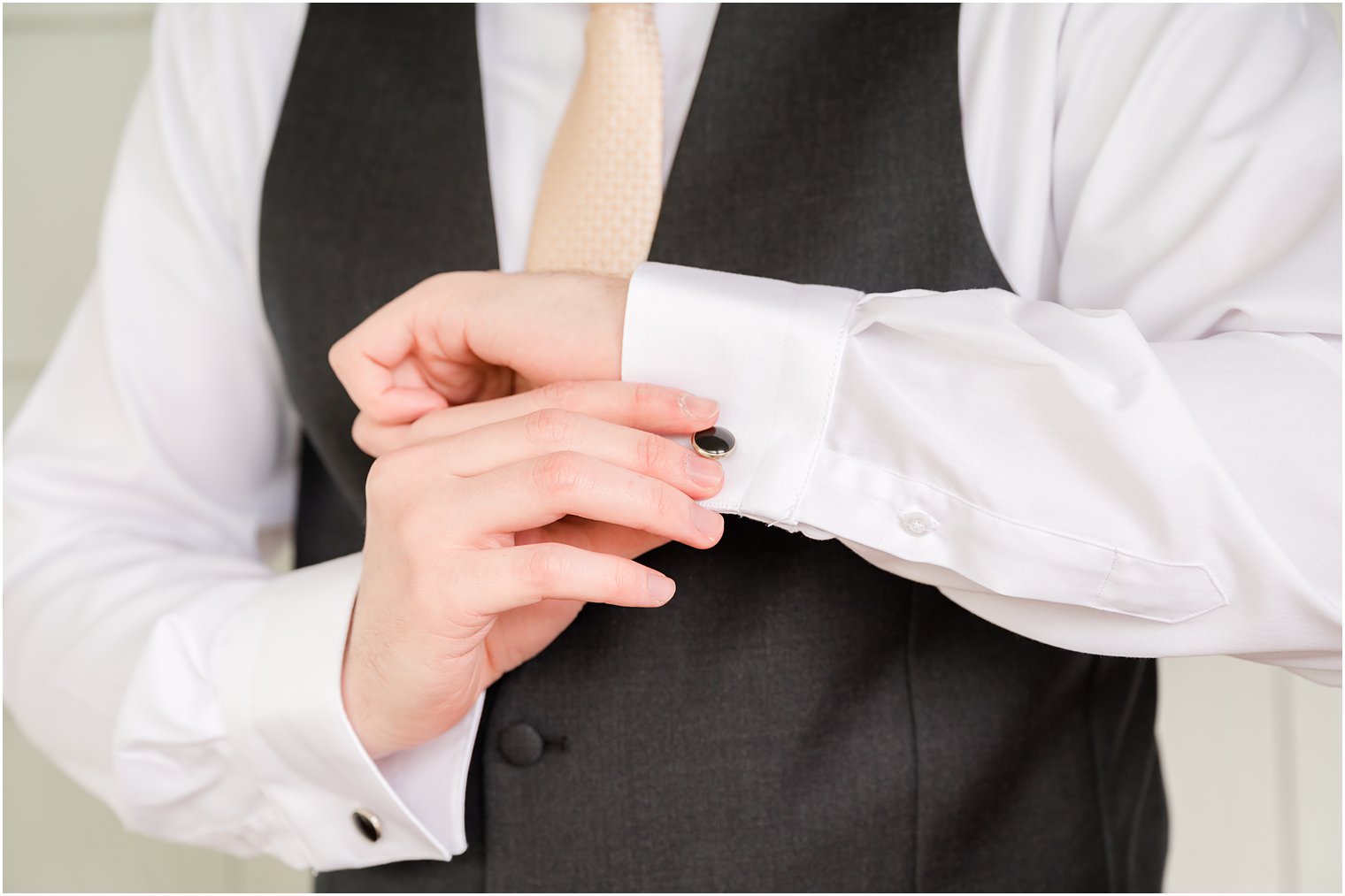 groom adjusts cufflinks before NJ wedding day