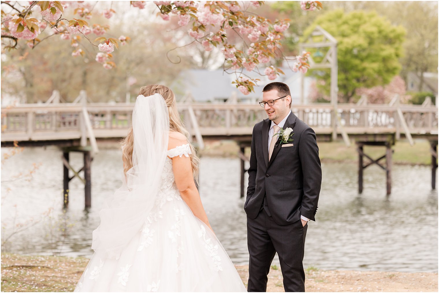 groom looks at bride during first look at Divine Park in Spring Lake NJ