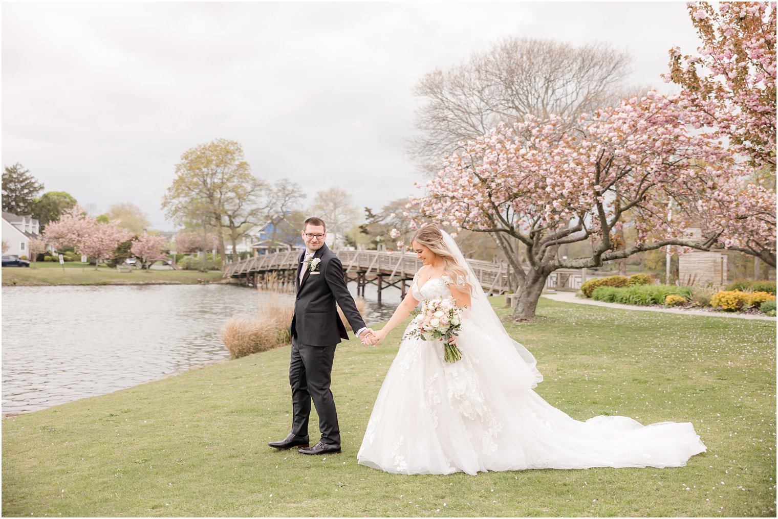 couple holds hands walking by pond in Divine Park in Spring Lake NJ