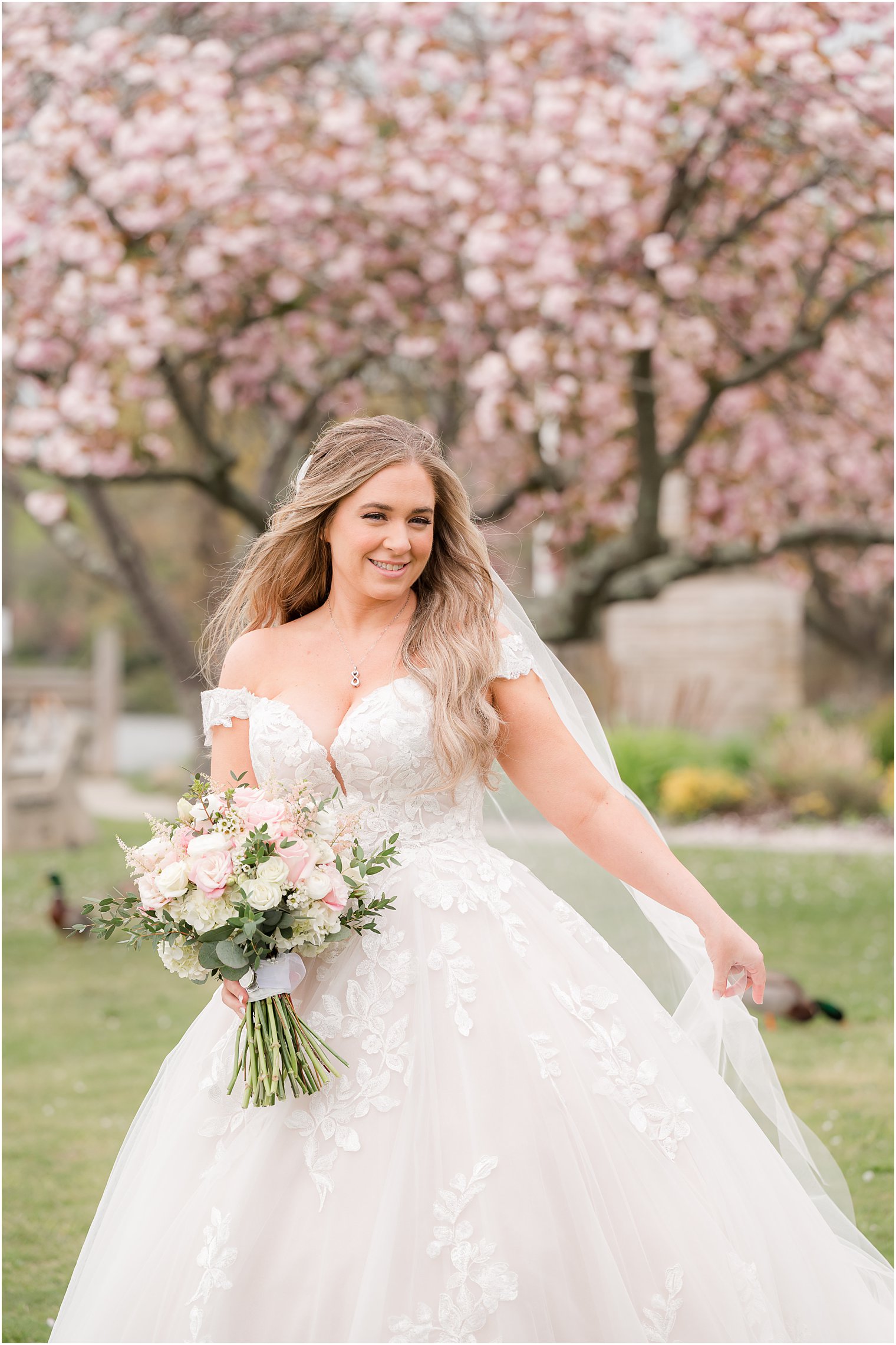 bride turns holding veil behind her in Divine Park in Spring Lake NJ