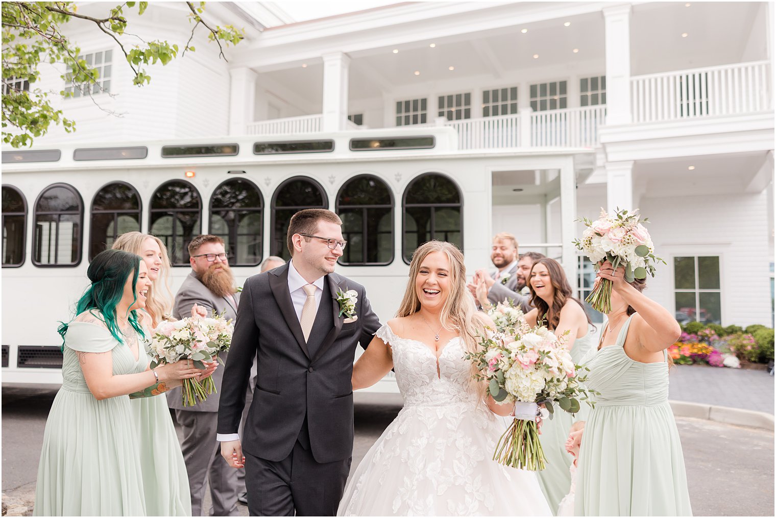 bride and groom smile walking through wedding party