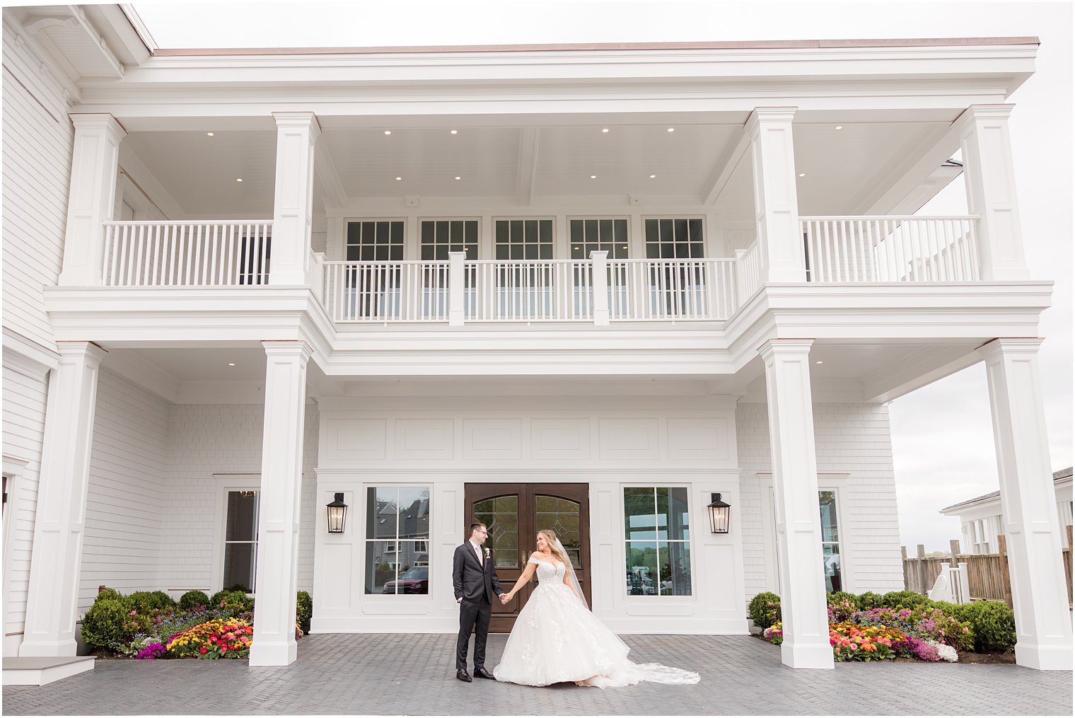 bride and groom hold hands standing outside Clark's Landing Yacht Club