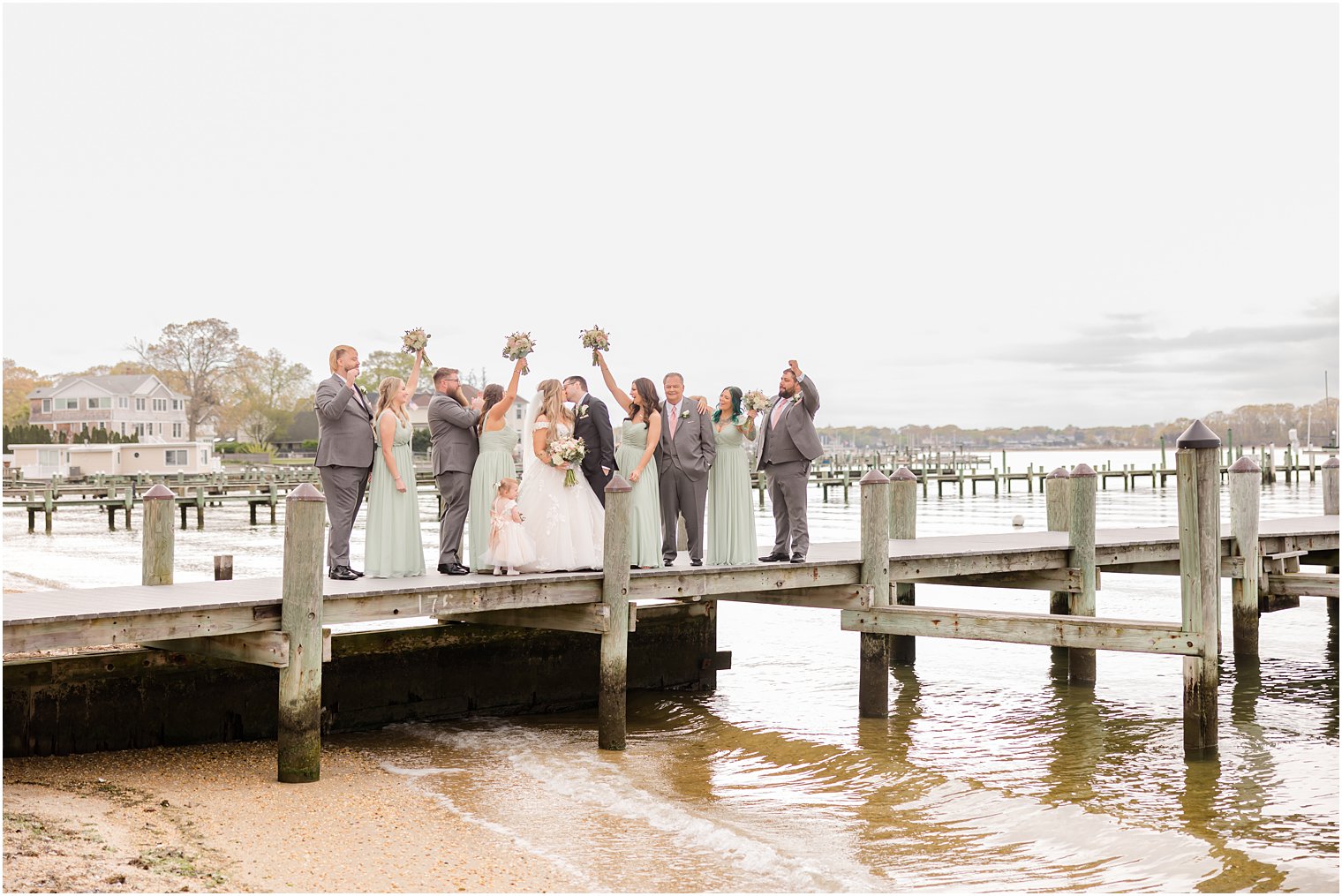 wedding party cheers standing on docks at Clark's Landing Yacht Club