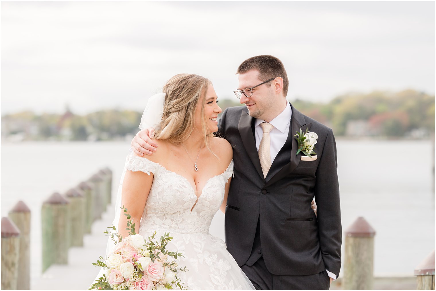 newlyweds hug on dock outside Clark's Landing Yacht Club