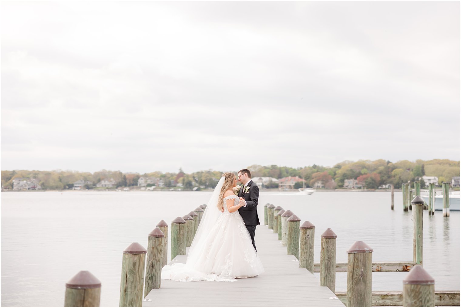 bride and groom kiss on dock at Clark's Landing Yacht Club