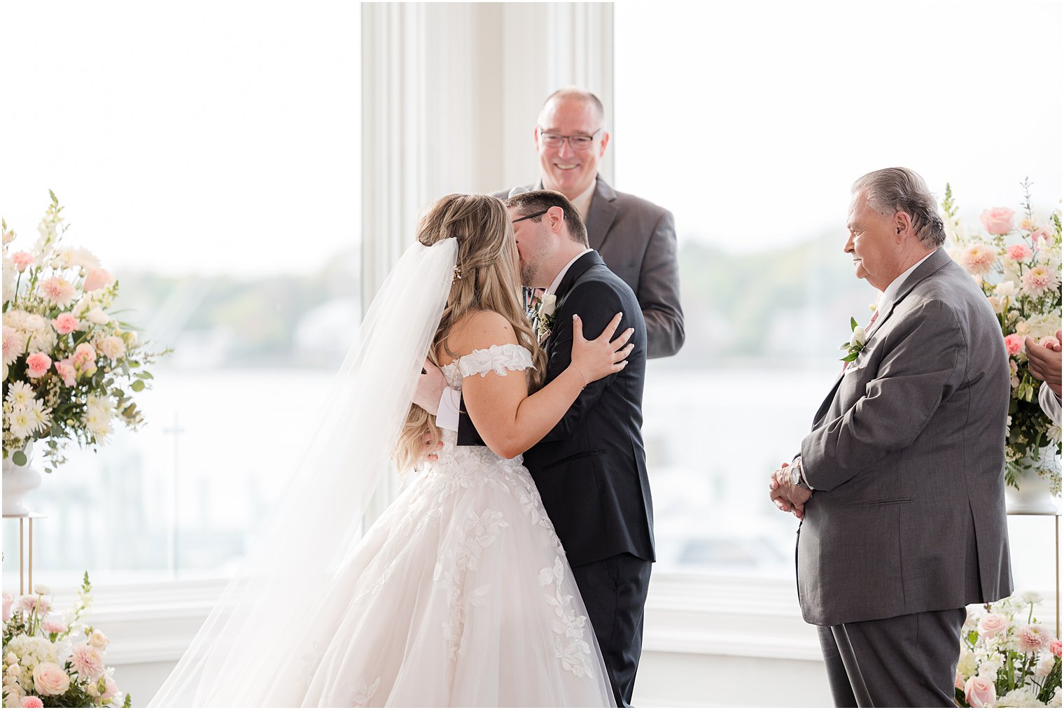 bride and groom kiss during Clark's Landing Yacht Club wedding ceremony