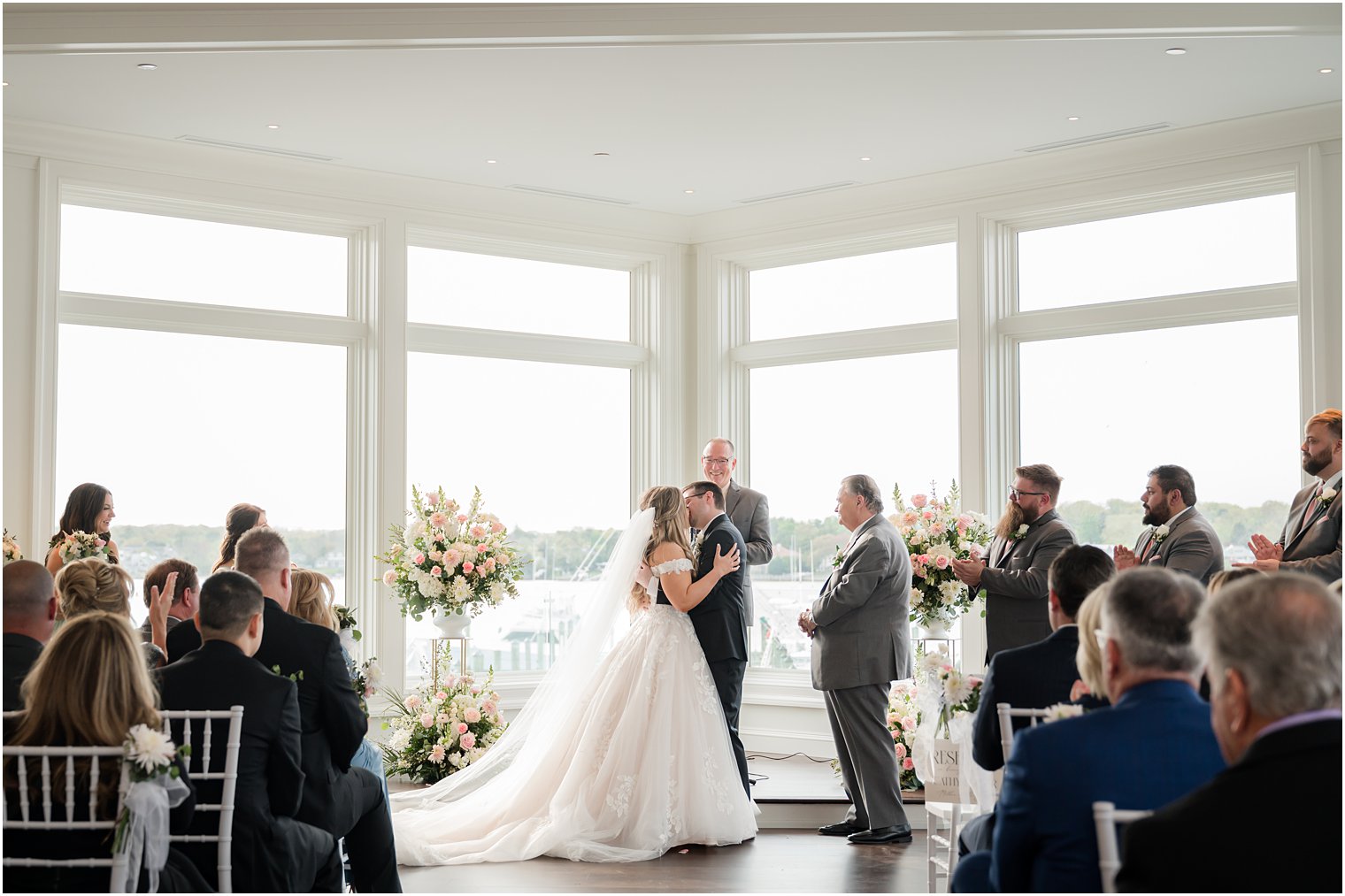 bride and groom kiss during Clark's Landing Yacht Club wedding ceremony
