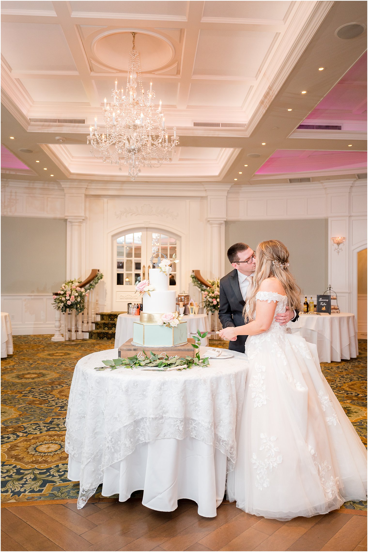 newlyweds kiss cutting wedding cake at Clark's Landing Yacht Club