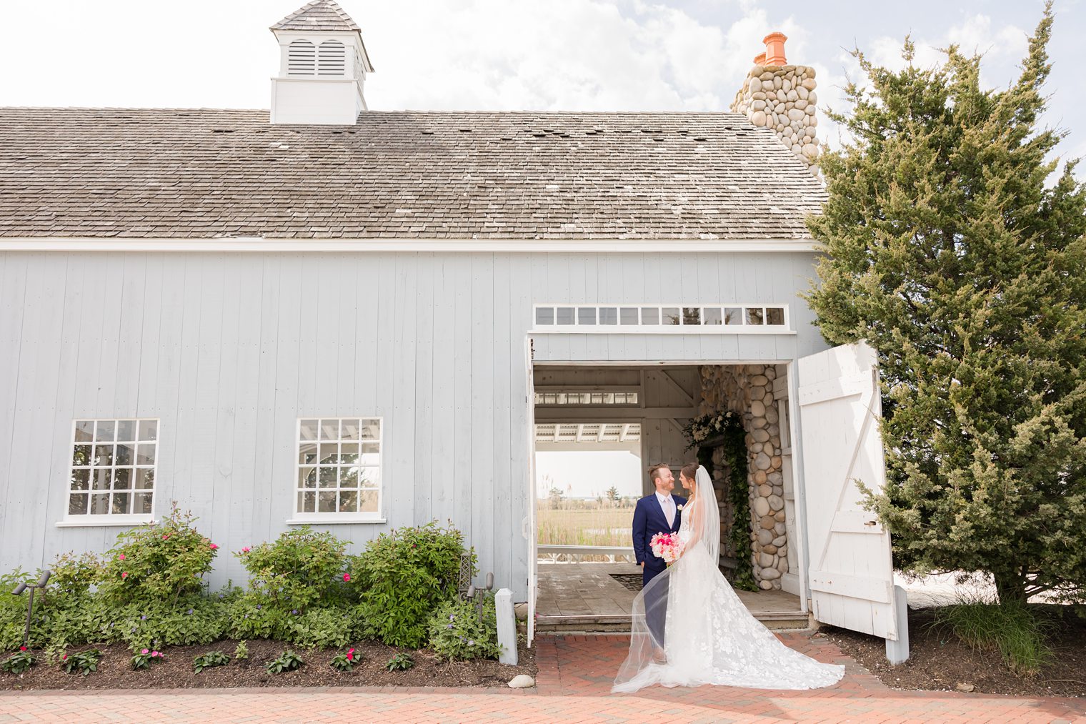 Bride and groom posing in front their venue at Bonnet Island Estate