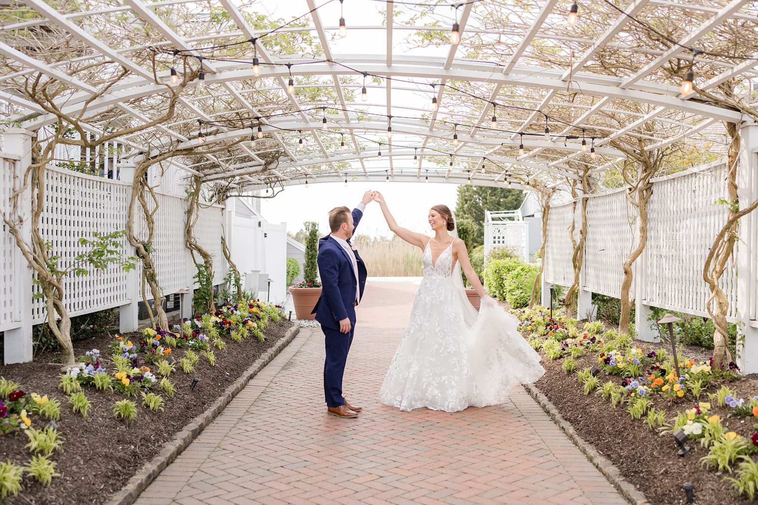 Fiance holding hands with his bride and making her dance