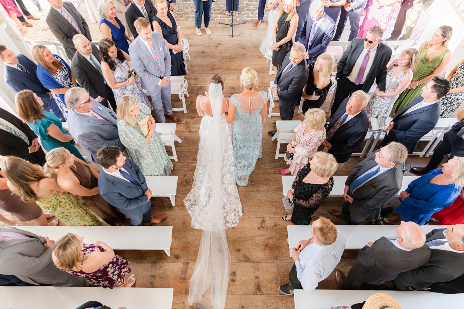 Bride walking trough the aisle with her mom 