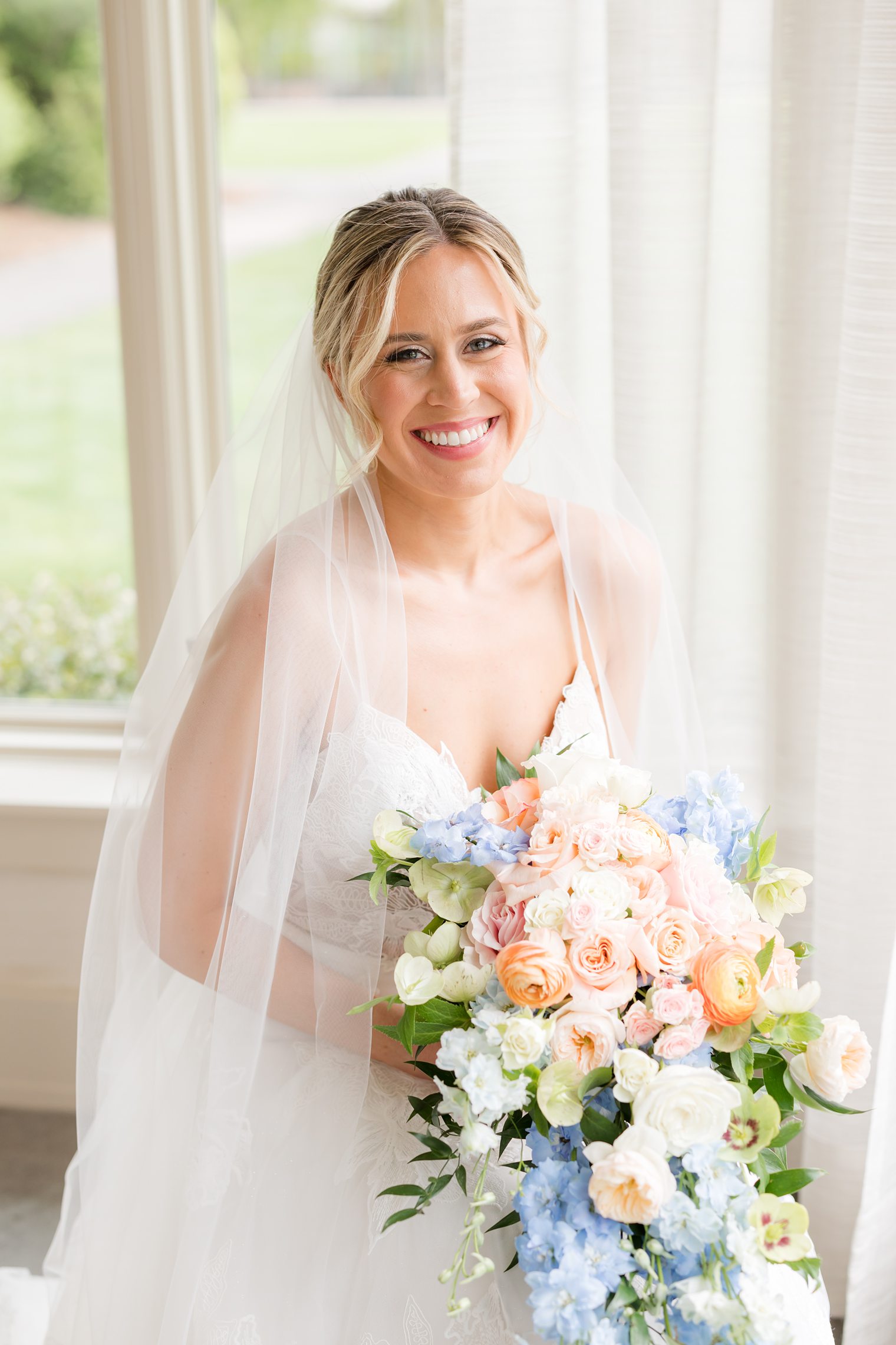 Bride and her white, blue and pink roses bouquet at the Indian Trail Club