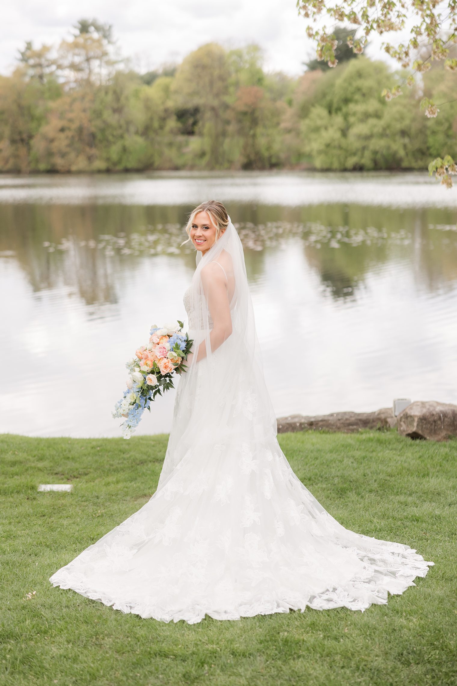 Bride posing showing her beautiful veil and bouquet 