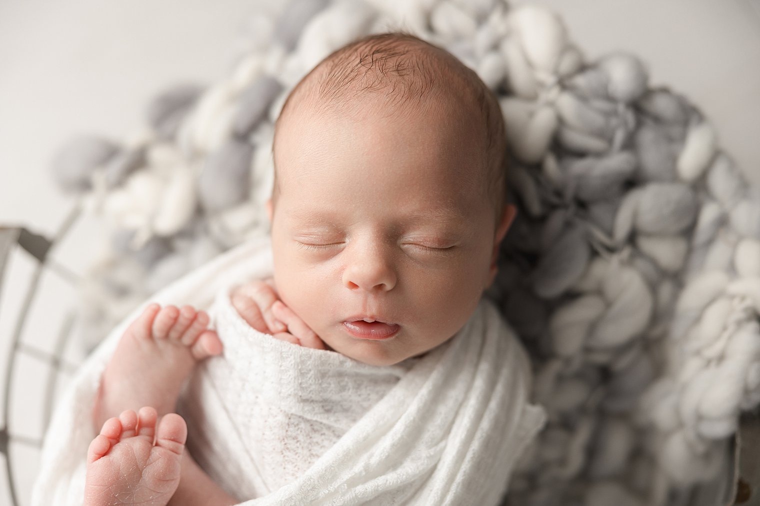 newborn boy sleeping in a basket