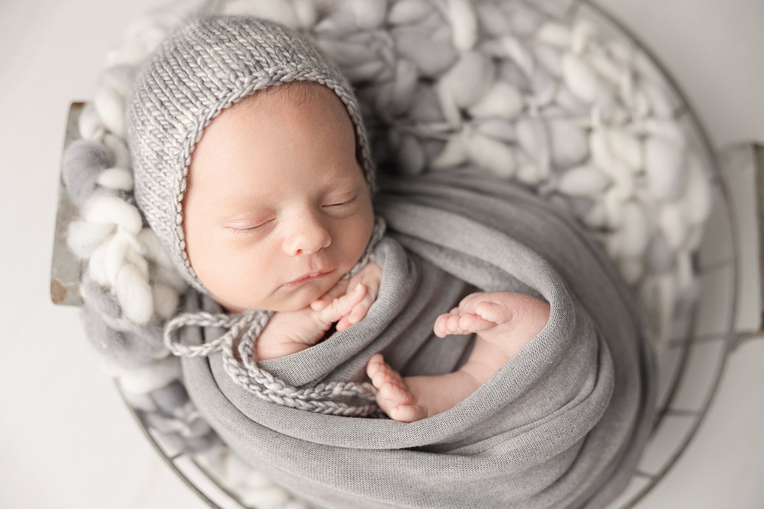 newborn boy swaddled in gray blanket