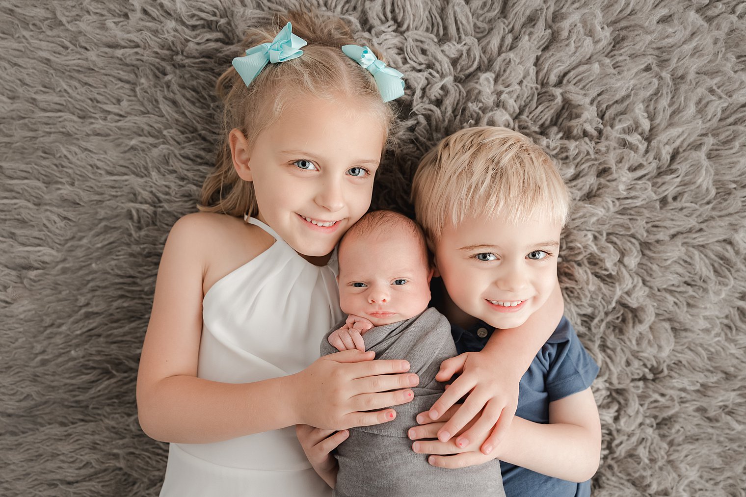 older siblings holding newborn brother by Point Pleasant NJ Newborn Photographer