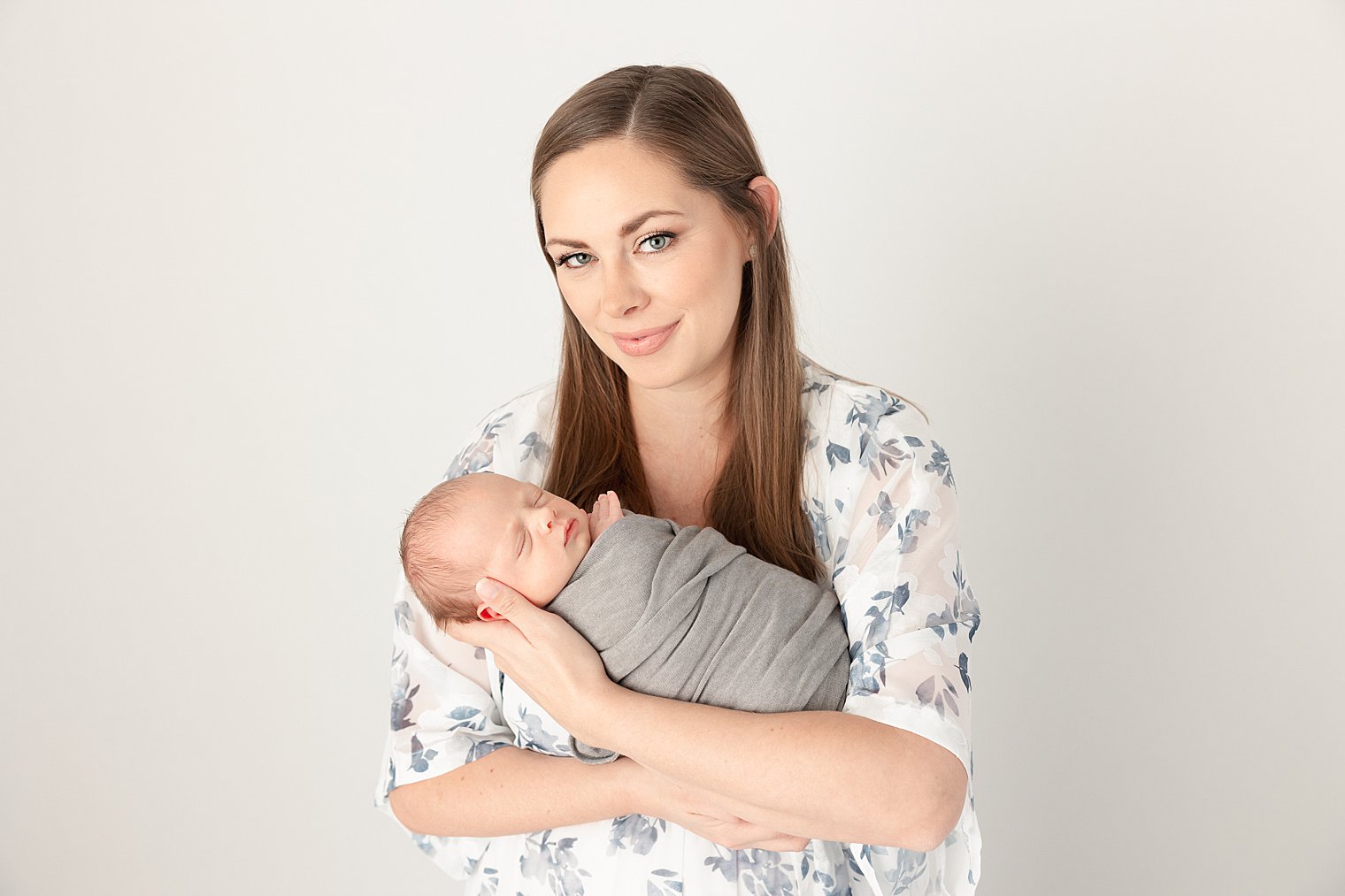 newborn baby with his mother wearing blue floral dress