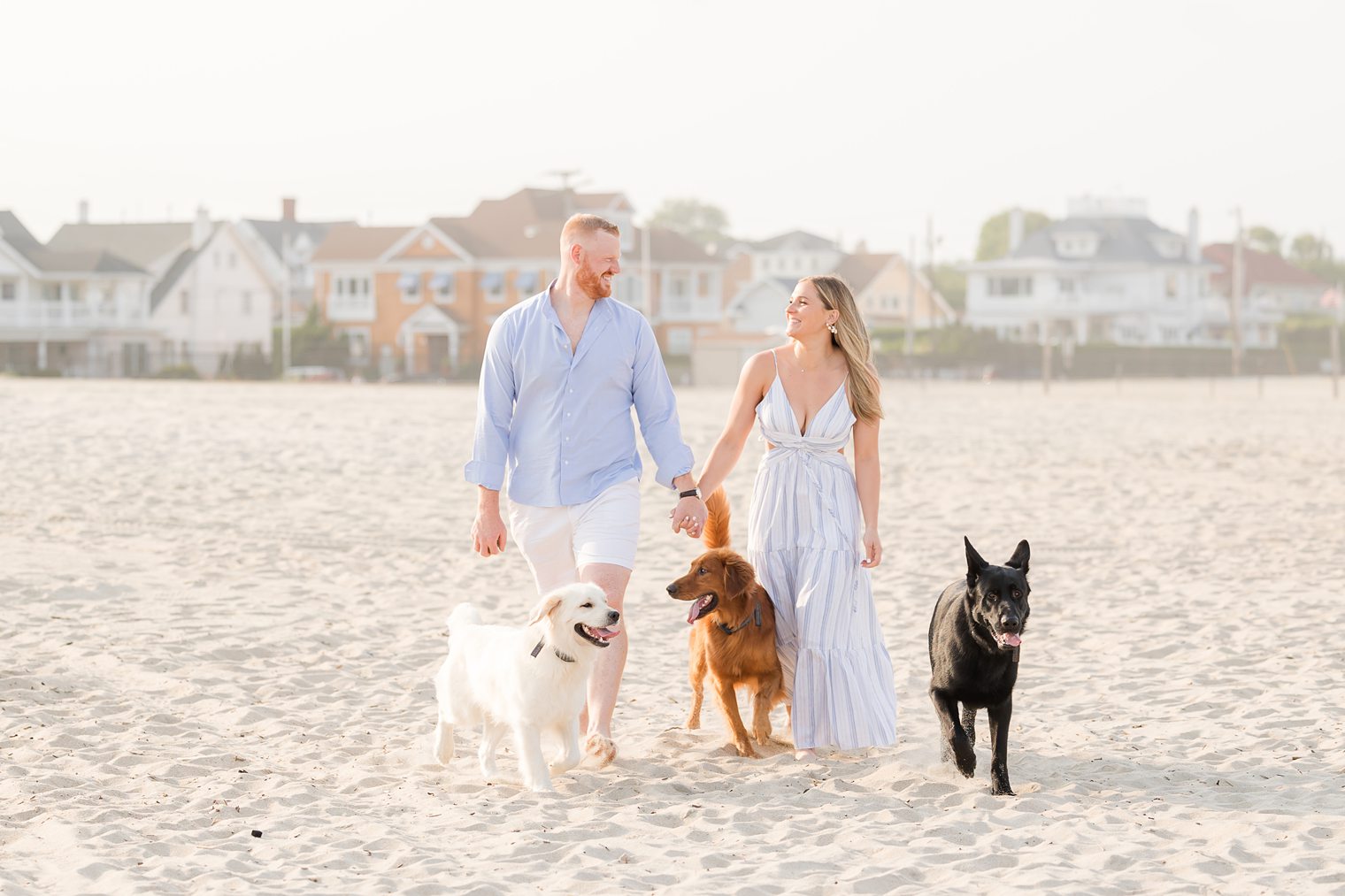 Future Mr and Mrs walking in the beach with their fur babies