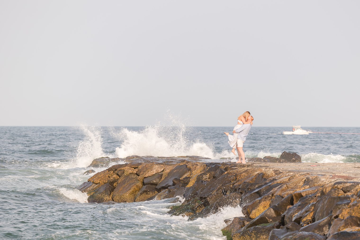 beautiful couple kissing while the waves create a picturesque background