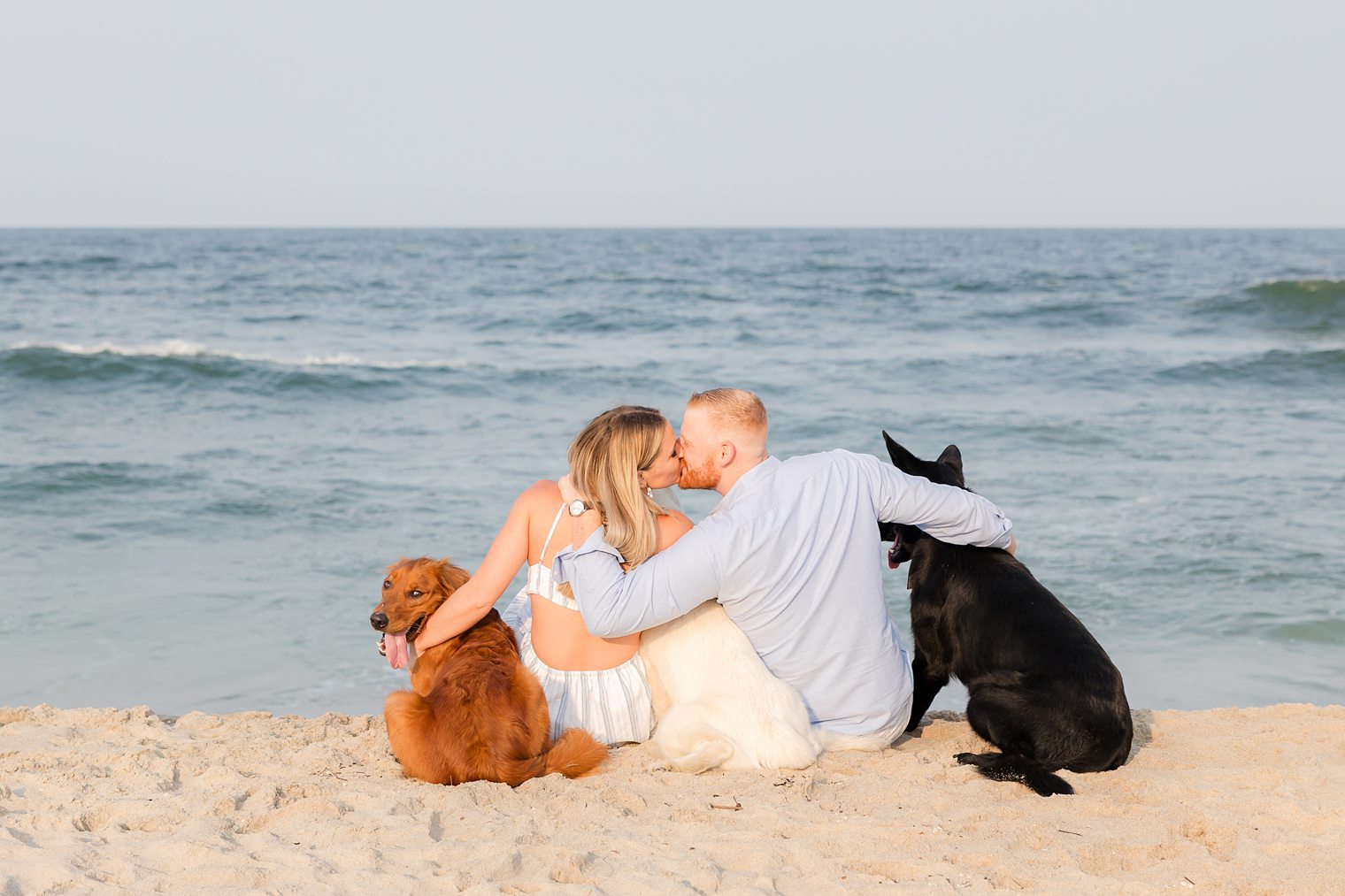 romantic couple enjoying the sea with their dogs 