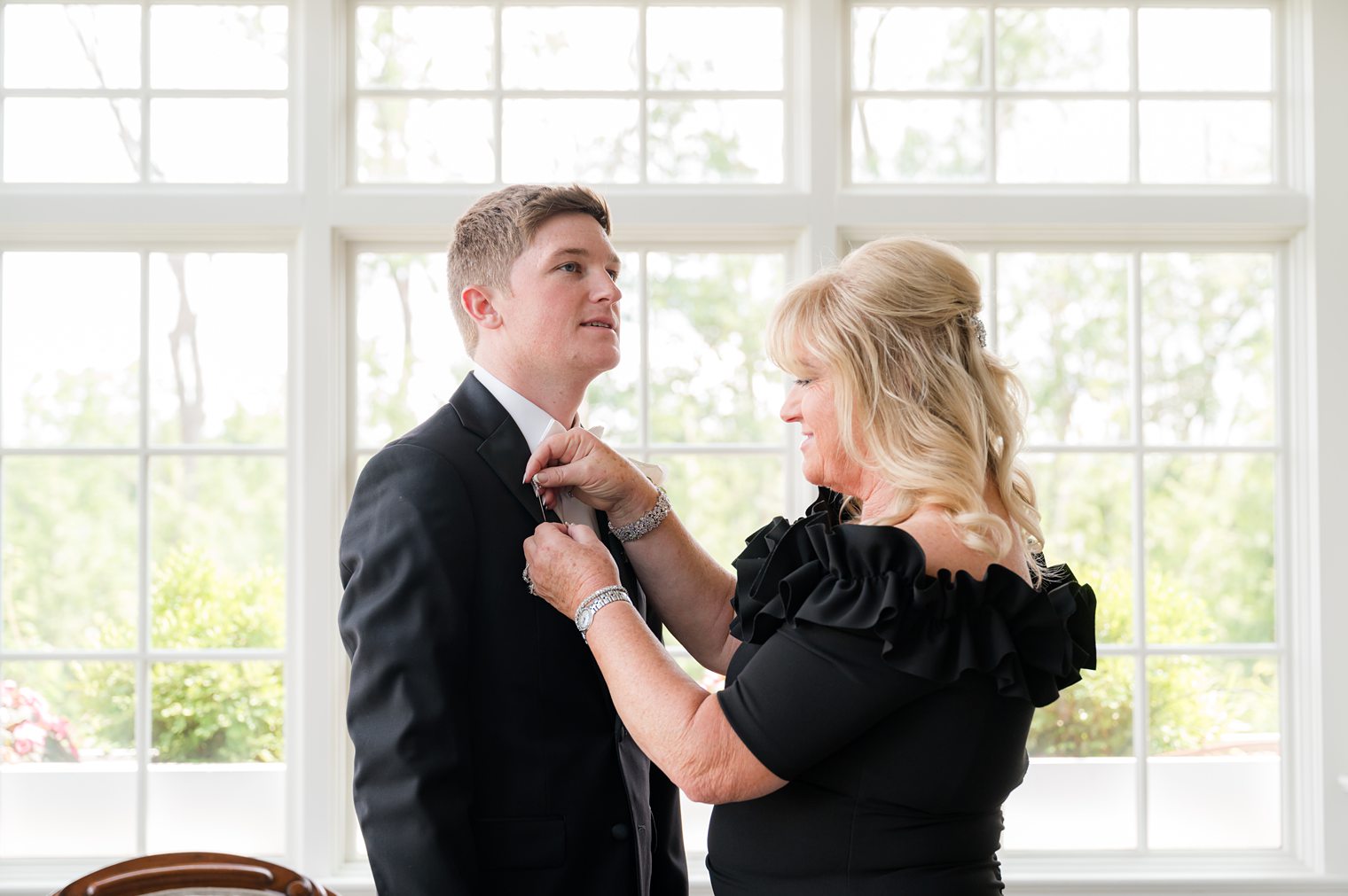 mother of the groom helping her son to finish getting ready at Park Savoy Estate