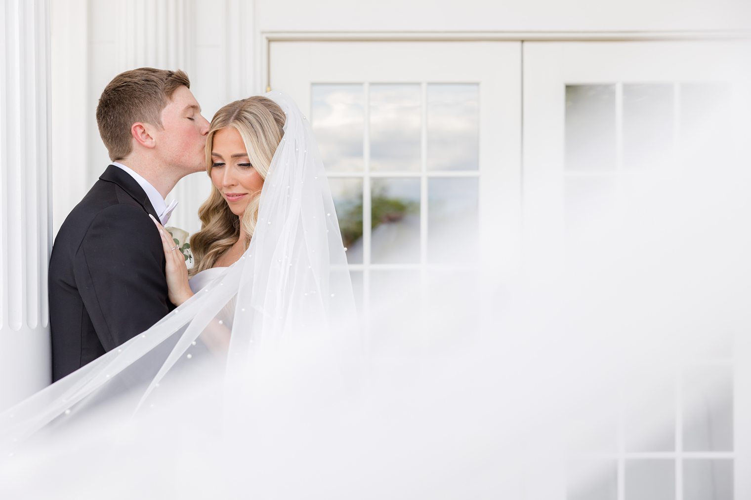 groom kissing his bride forehead 