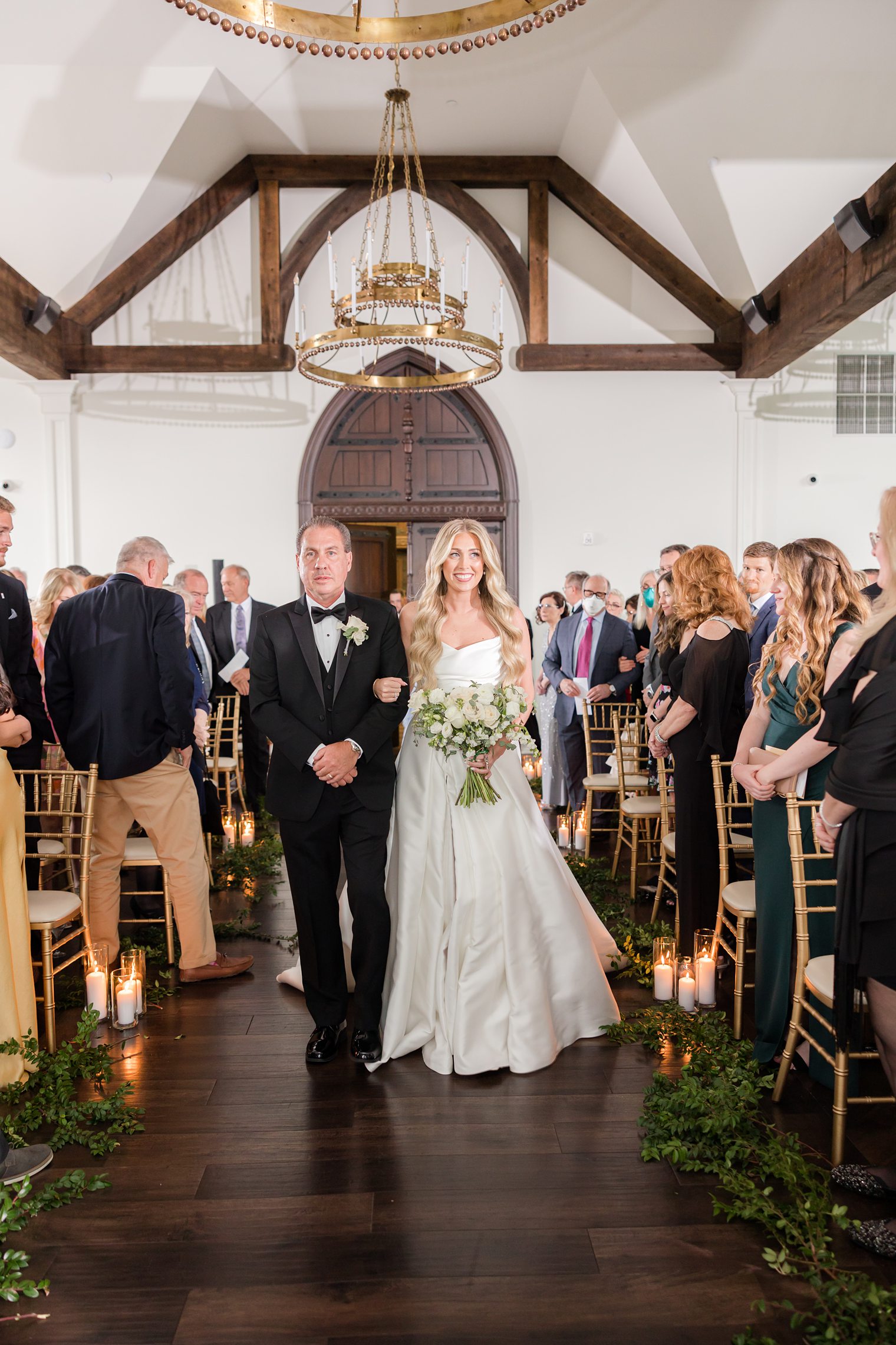 Happy bride walking into the aisle with her father