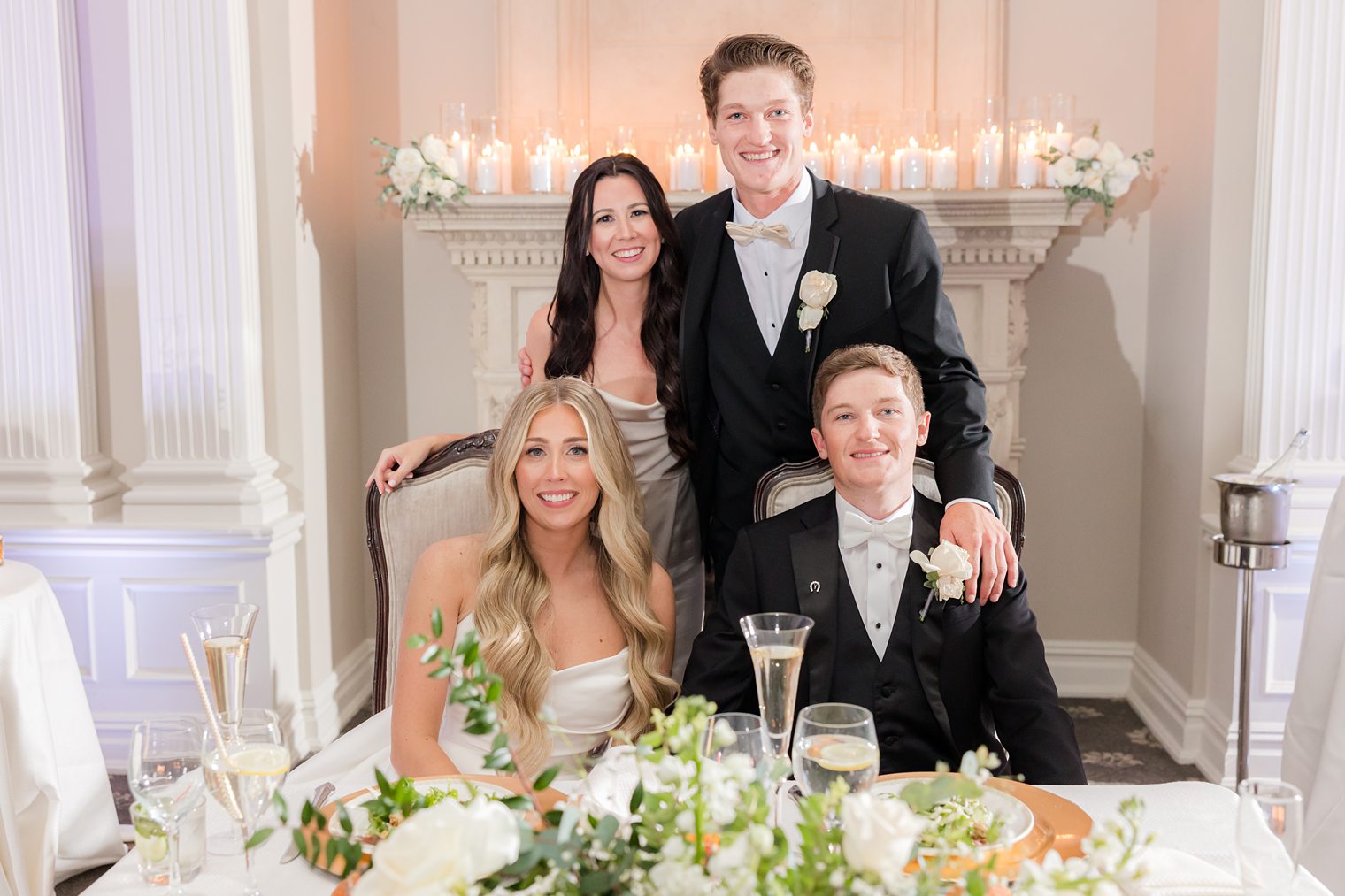 Husband and wife at their sweet table with bridesmaid and best man 