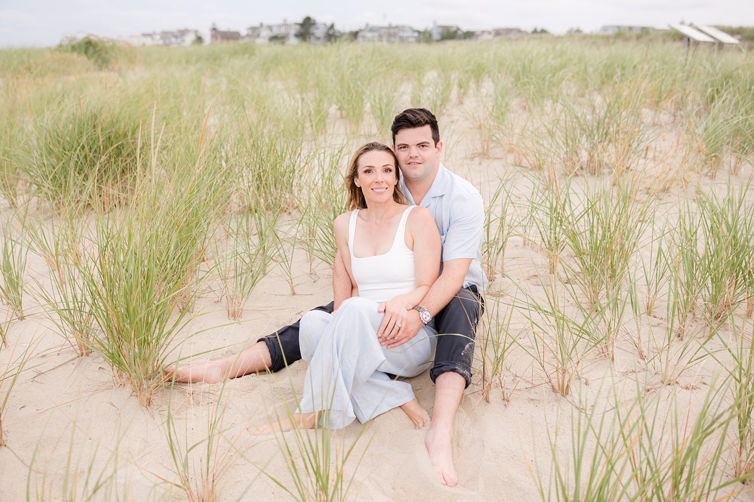 Future husband and wife sitting in the sand at Bay Head