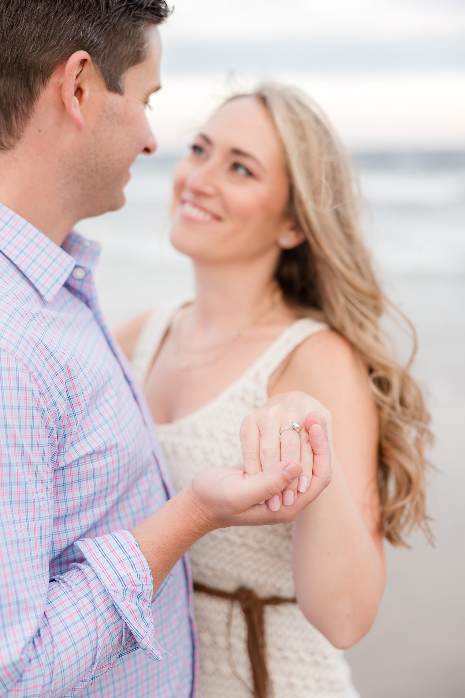 fiancé holding his bride hand to show the engagement ring