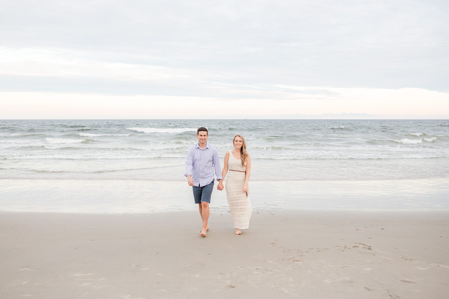 fiancé and bride holding hands at the beach