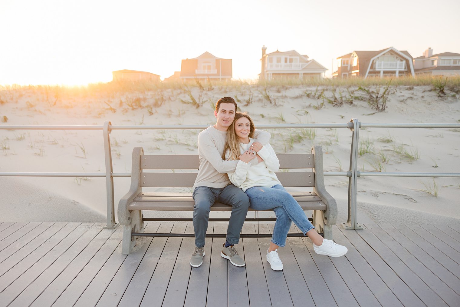 Bride and future husband sitting on a bench hugging each other 