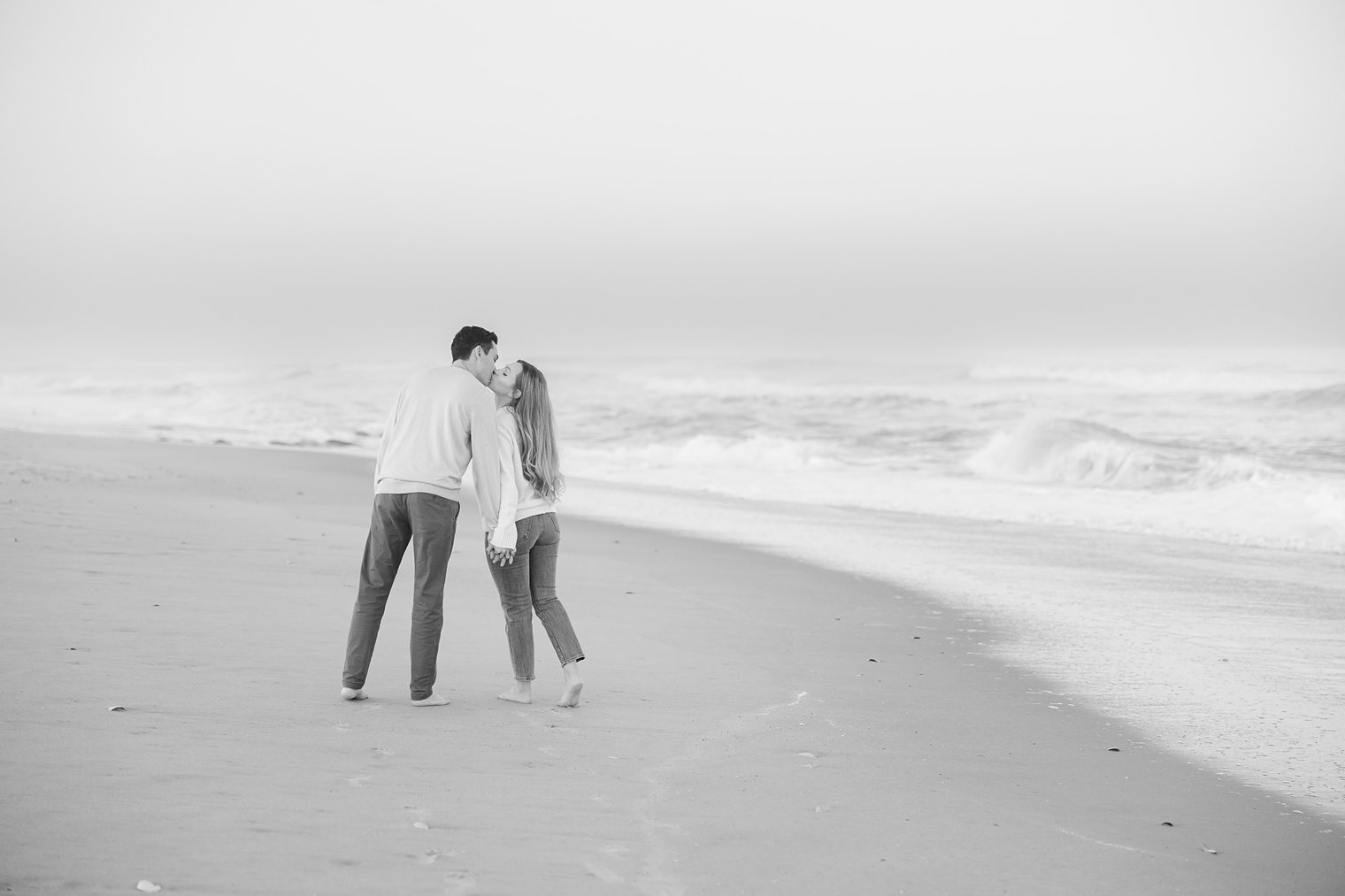fiancé and bride kissing each other at the beach 