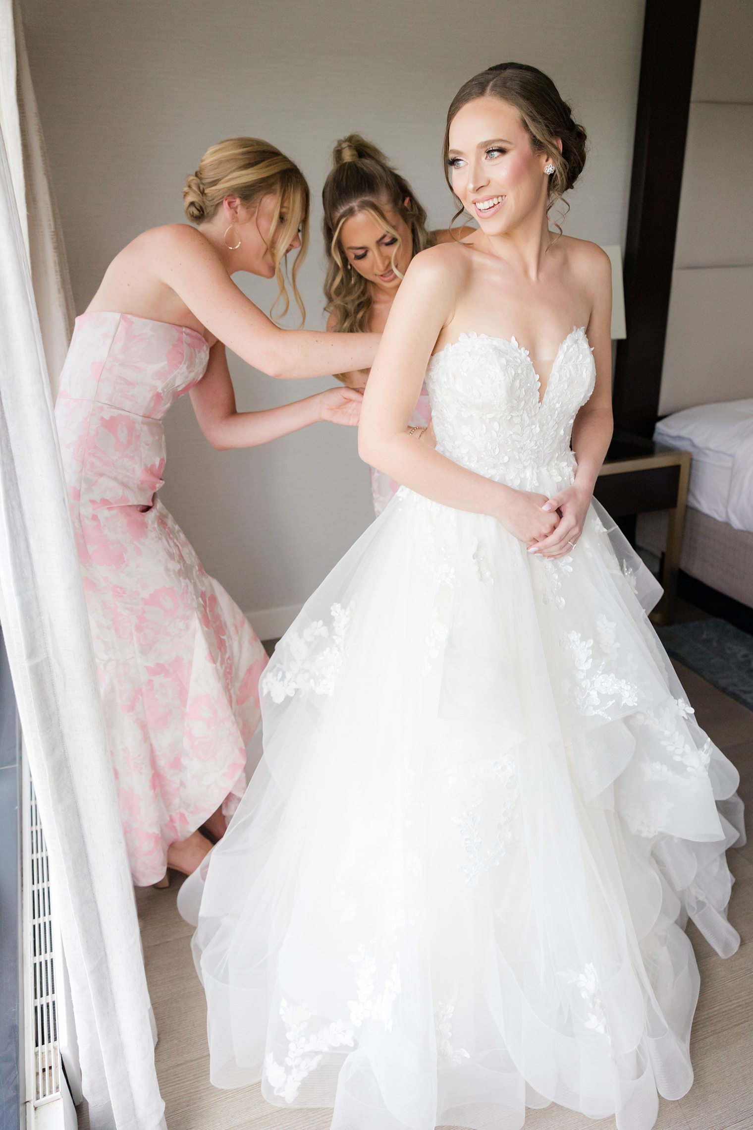 Bridesmaids helping the bride to finish get ready
