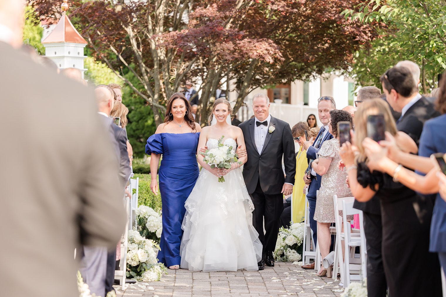 bride walking down the aisle with her parents