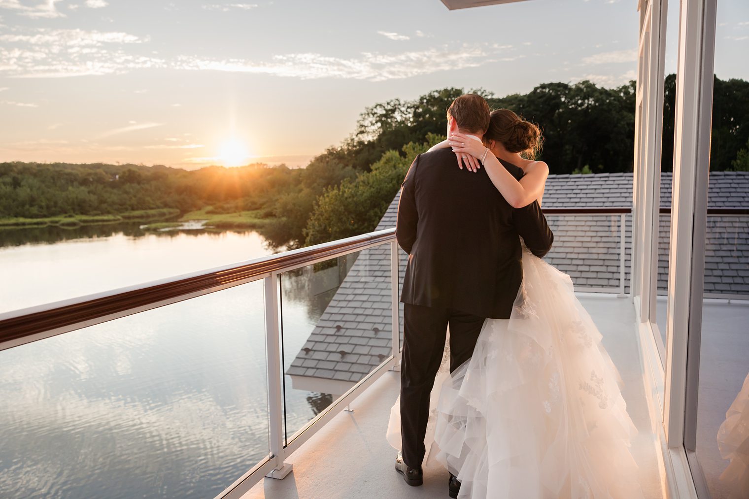 bride and groom huggin each other looking at the sunset