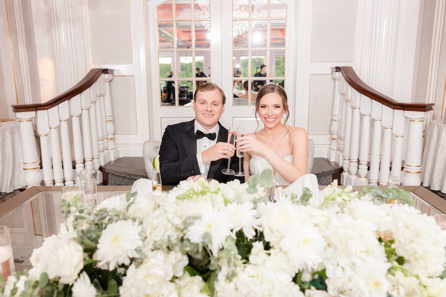 Mr and Mrs sitting on their sweet heart table