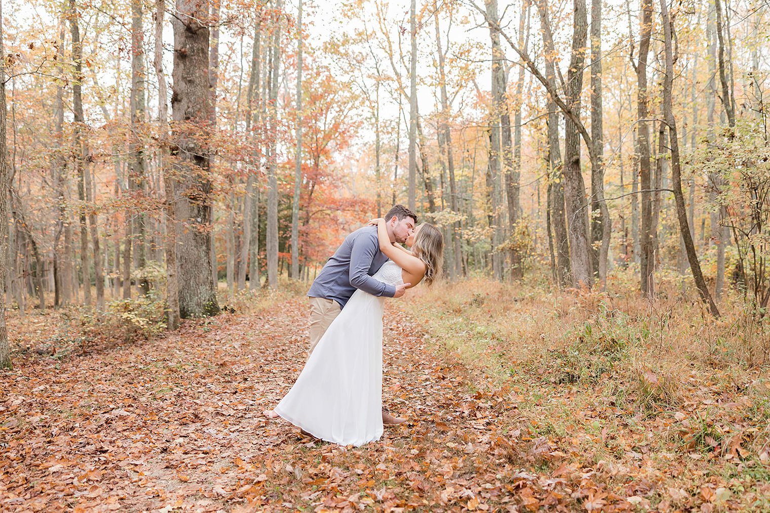 Future husband and wife sharing a kiss at Allaire State Park