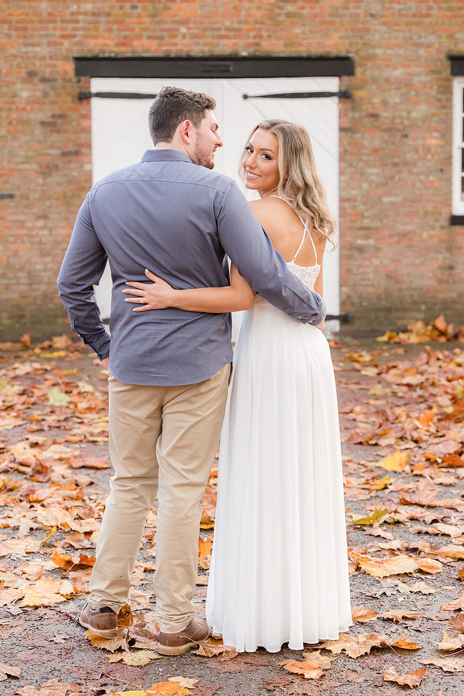 bride and fiancé hugging, while bride looks to the camera 